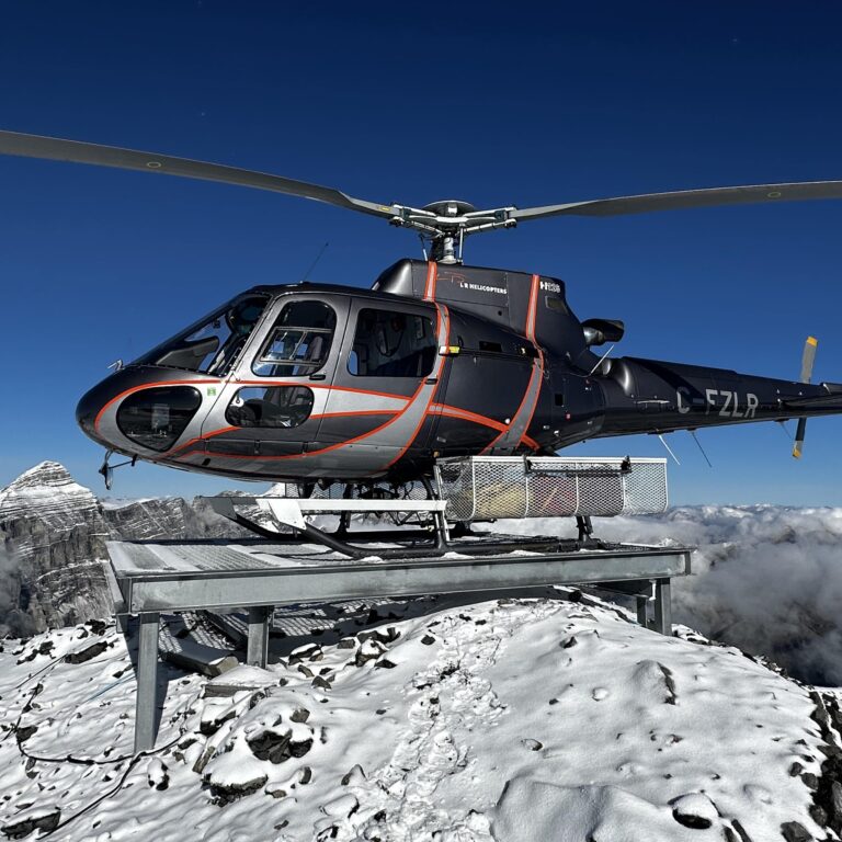 AS350 C-FZLR on high-altitude snow summit helipad above clouds — L R Helicopters helicopter tours Canadian Rockies, Calgary, Alberta