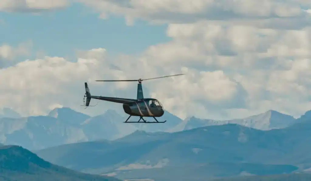 Robinson R44 helicopter in flight over Alberta foothills during Introductory FAM Flight Experience with L R Helicopters near Calgary